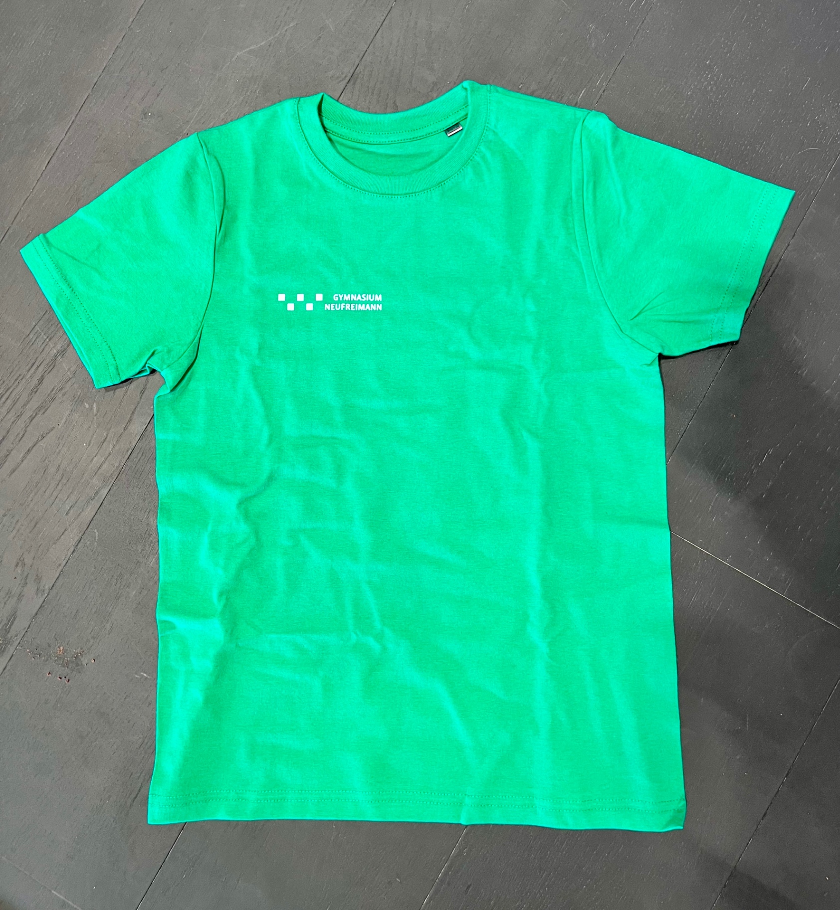 Green T-shirt with the Gymnasium Neufreimann lettering for the choir class and tech crew